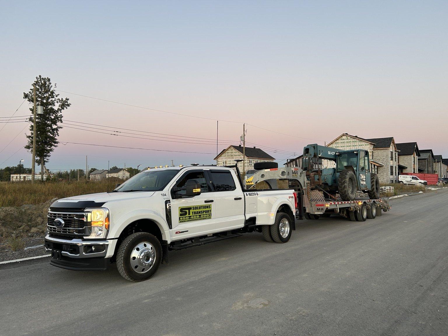 Transport de machinerie sur une remorque plateforme de Solutions Transport
